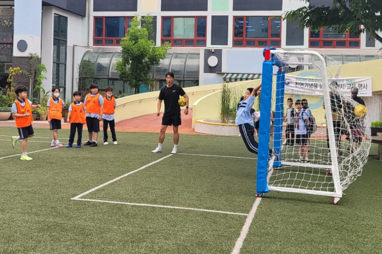 선생님의 지도에 따라 축구 활동중인 아이들 사진